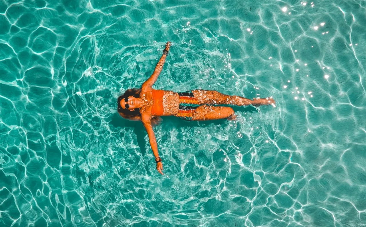 Mujer relajándose en una piscina exterior durante un día de verano