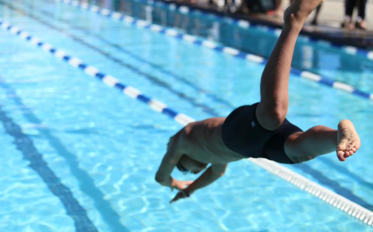 Hombre lanzándose al agua para comenzar una rutina de natación.