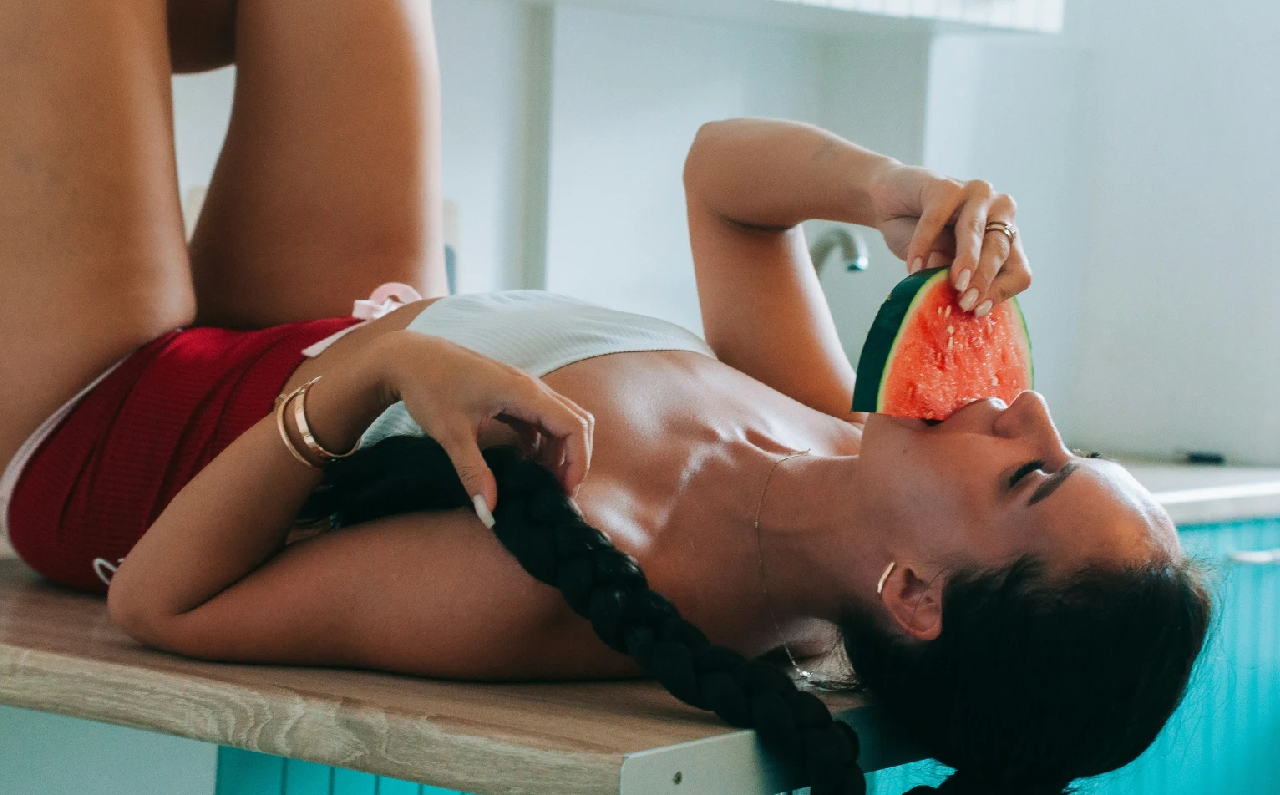 Mujer disfrutando de una sandía fresca, una de las frutas de temporada más hidratantes del verano