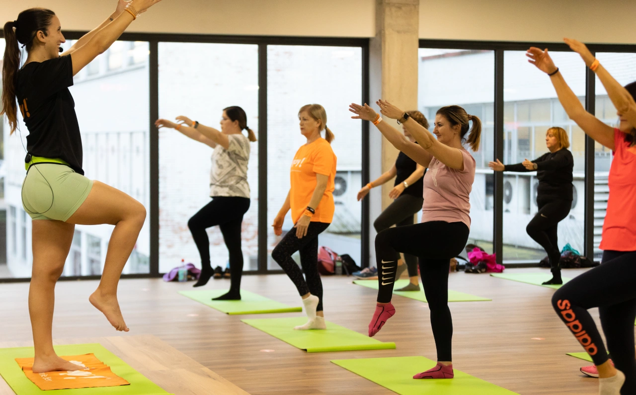 Grupo de personas participando en una clase dirigida en un gimnasio Enjoy!